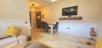 a living room with a couch and a table with chairs at appart Marrakech in Marrakech