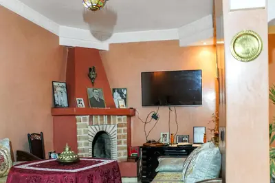 a living room with a fireplace and a tv at Riad La Famille in Marrakech