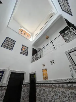 a room with a white wall with a ceiling with tiles at Riad TaTam House in Marrakech