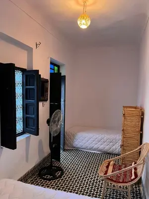 a room with a fan and a bed and a window at Riad TaTam House in Marrakech