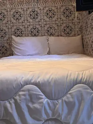 a bed with white sheets and pillows in a bedroom at Riad TaTam House in Marrakech