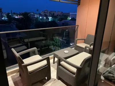 a balcony with a table and chairs on a balcony at Superbe appartement à l Hivernage in Marrakech