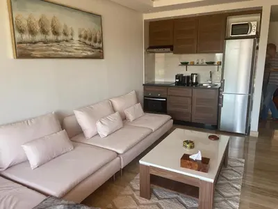 a living room with a white couch and a kitchen at Superbe appartement à l Hivernage in Marrakech