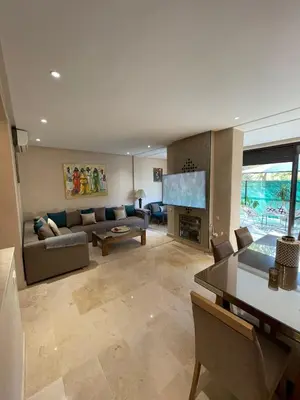 a living room with a couch and a television at villa jardin de l'Atlas in Marrakech
