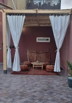 a living room with a couch under a canopy at Marrakech medina inn in Marrakech