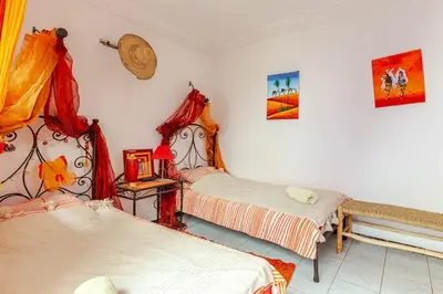 a bedroom with two beds and a table with avertisement at Riad Sofia signature in Marrakech