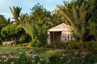 a yurt in a garden with trees and flowers at Pavillon Terra Ababila en Exclusivité in Marrakech