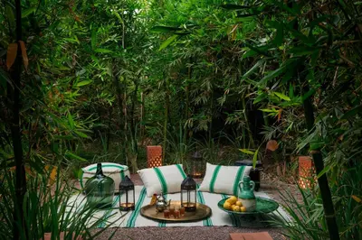 a patio with a table and chairs in a garden at Pavillon Terra Ababila en Exclusivité in Marrakech