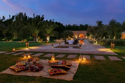a table with candles and lights in the grass at Pavillon Terra Ababila en Exclusivité in Marrakech