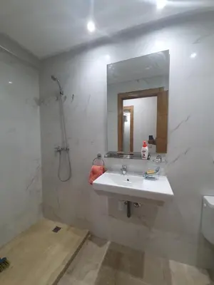 a white bathroom with a sink and a mirror at Deluxe Apartment in Marrakesh. hevernage flat in Marrakech