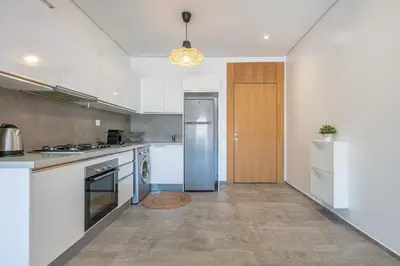 a kitchen with white appliances and a wooden door at Haut-Standing, Marrakech Guéliz, Piscine in Marrakech