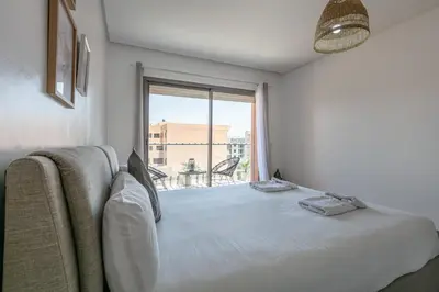 a bedroom with a bed and a large window at Haut-Standing, Marrakech Guéliz, Piscine in Marrakech