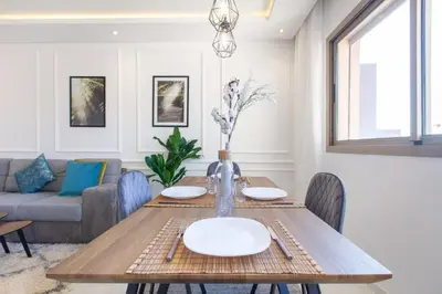 a dining room with a table and a couch at NEW! Cosy, Lux , Gueliz centre, Iptv in Marrakech