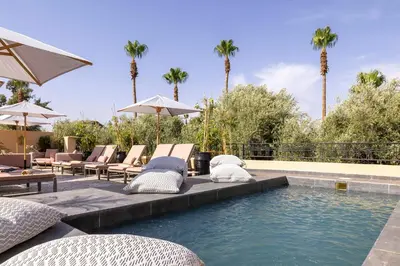 a swimming pool with lounge chairs and an umbrella at Riad LAZ Mimoun & Spa in Marrakech