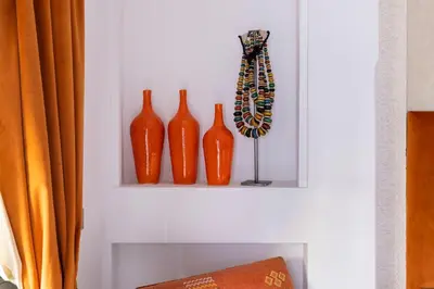 four orange vases on a shelf on a wall at Riad LAZ Mimoun & Spa in Marrakech