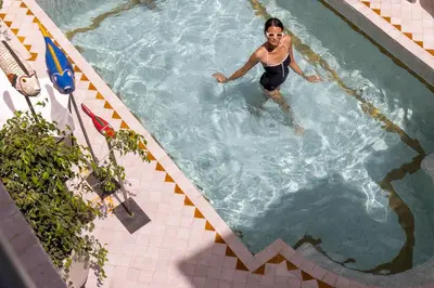 a woman is standing in a swimming pool at Riad LAZ Mimoun & Spa in Marrakech