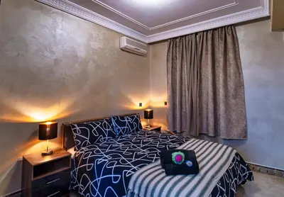 a bedroom with a black and white bed and a window at Harmony Inn Entire 2 bedroom apartment in Marrakech