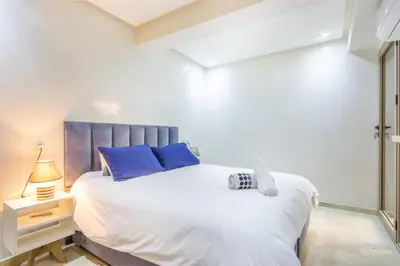 a bedroom with a large white bed with blue pillows at Relax, Modern, Centre Gueliz in Marrakech