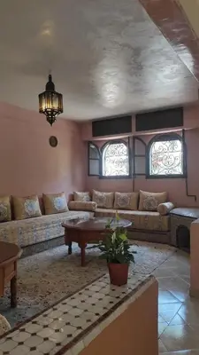 a living room with a couch and a table at Maison style riad aux chants des oiseaux in Marrakech
