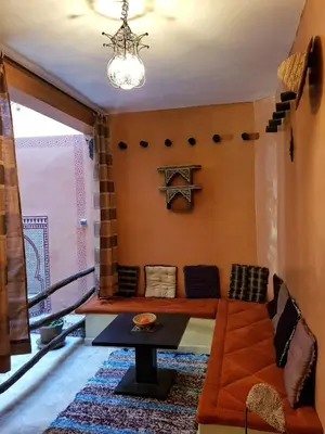a living room with a couch and a table at Maison style riad aux chants des oiseaux in Marrakech