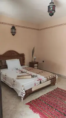 a bedroom with a large bed in a room at Maison style riad aux chants des oiseaux in Marrakech