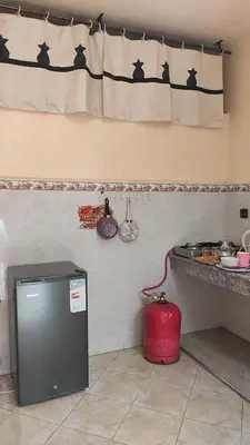 a kitchen with a counter and a red refrigerator at Maison style riad aux chants des oiseaux in Marrakech