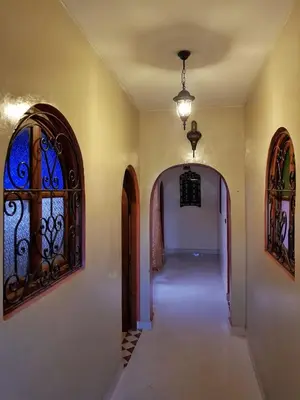 an empty hallway with two arches and a window at Maison style riad aux chants des oiseaux in Marrakech