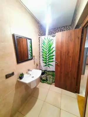a bathroom with a sink and a wooden door at Bonheur Partagé 1 in Marrakech