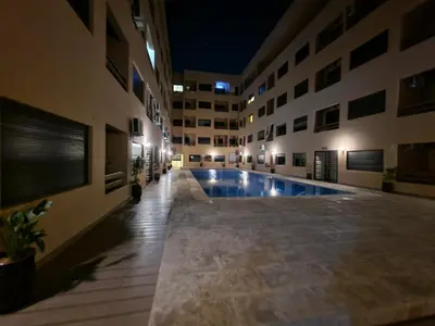 a swimming pool in the middle of a building at night at Bonheur Partagé 1 in Marrakech