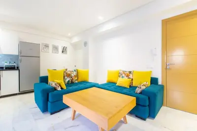 a living room with a blue couch and yellow pillows at NEW! Luxury’n Colorful, Gueliz in Marrakech