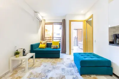 a living room with a blue couch and a table at NEW! Luxury’n Colorful, Gueliz in Marrakech
