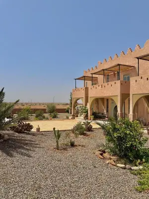 a large building in the middle of a desert at Riad Nohad Marrakech Villa Privatisée in Oulad Boudene