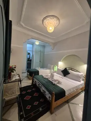 a bedroom with two beds and a chandelier at Dar 
