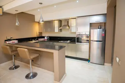 a kitchen with a large counter and a refrigerator at studio design carre eden gueliz IPTV , NETFLIX , WIFI, in Marrakech