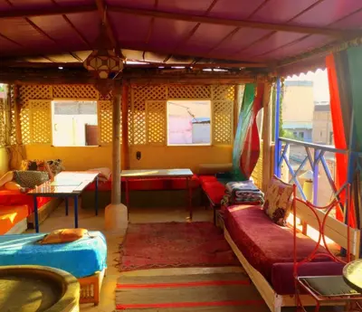 a room with two beds and a couch and a table at Riad Dia in Marrakech