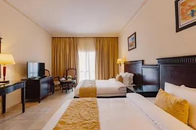 a hotel room with two beds and a television at Grand Mogador Agdal & Spa in Marrakech