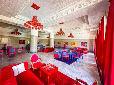 a large room with red and blue chairs and tables at Grand Mogador Agdal & Spa in Marrakech