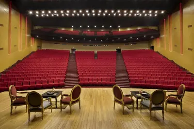 an auditorium with red seats and tables and chairs at Grand Mogador Agdal & Spa in Marrakech