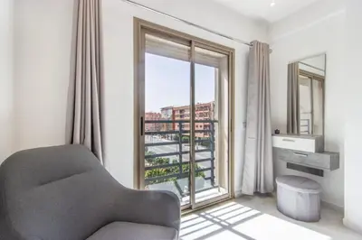 a living room with a chair and a large window at NEW! Élégance, Gueliz, Terrase, IPTV in Marrakech
