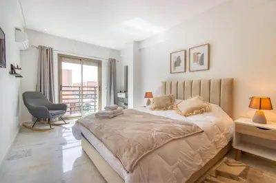a bedroom with a bed and a chair and a window at NEW! Élégance, Gueliz, Terrase, IPTV in Marrakech
