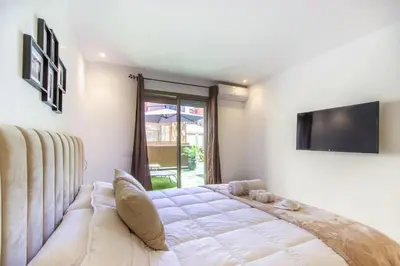 a bedroom with a bed and a tv on the wall at NEW!, Jardin privé, transats, barbecue in Marrakech