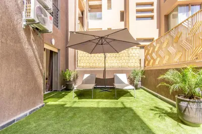 a patio with a table and chairs and an umbrella at NEW!, Jardin privé, transats, barbecue in Marrakech
