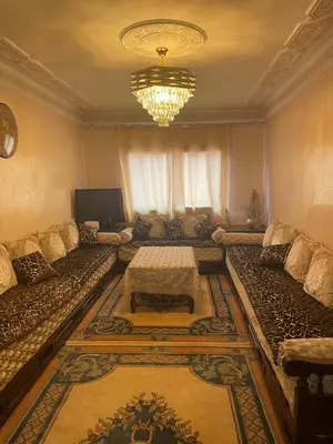 a living room with a couch and a table at Appartement dans résidence avec piscine in Marrakech