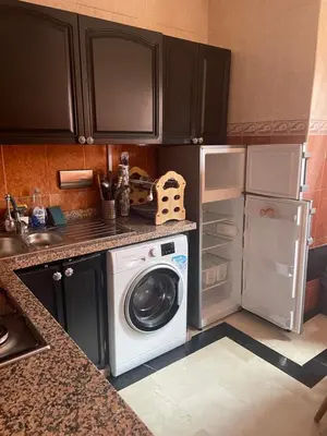 a kitchen with a washing machine and a refrigerator at Appartement dans résidence avec piscine in Marrakech