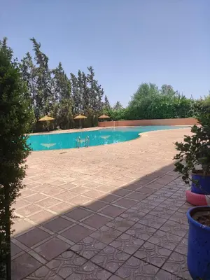 a large swimming pool with blue water in a yard at Appartement dans résidence avec piscine in Marrakech