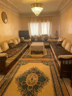 a living room with a couch and a table at Appartement dans résidence avec piscine in Marrakech