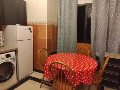 a kitchen with a table with a red and white polka dot table cloth at Appartement dans résidence avec piscine in Marrakech