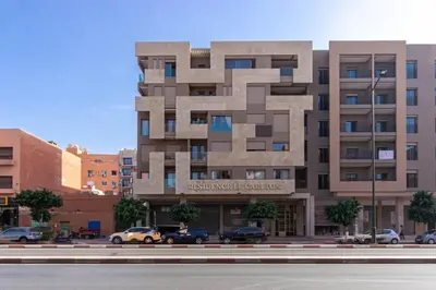 a large building with cars parked in front of it at NEW! Appartement de luxe emplacement idéal Gueliz in Marrakech