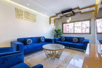 a living room with blue couches and a table at NEW! Appartement de luxe emplacement idéal Gueliz in Marrakech