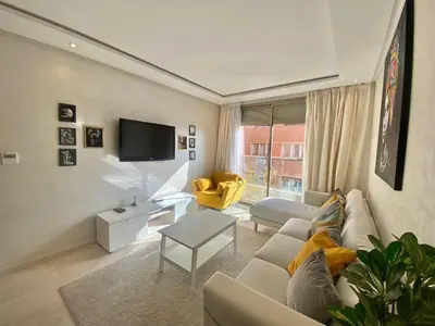 a living room with a couch and a tv at APPARTEMENT CARRE EDEN in Marrakech